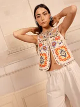 Chaleco negro con bordado floral multicolor, sin mangas y corte recto.