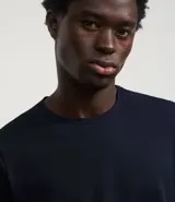 Remera slim de manga corta color salmón, de punto medio, sin estampado y cuello redondo.