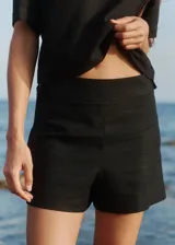 Short negro de tiro alto confeccionado en lino y rayón, con cierre invisible y doble botón lateral.