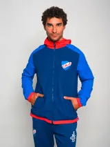 Campera deportiva con capucha, azul con mangas celestes y detalles en rojo. Escudo del Club Nacional de Football bordado en el pecho.