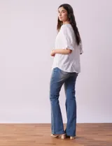 Blusa blanca calada con escote en V, mangas cortas con hombros fruncidos y puños elastizados.