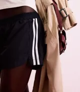 Short deportivo femenino color blanco, de poliéster, con cintura elástica, abertura lateral y bolsillo trasero.