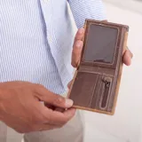 Billetera negra de símil cuero con banda elástica horizontal blanca. Interior con doble compartimento para billetes, visor y tarjeteros.