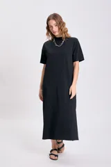 Vestido largo negro de corte recto, con cuello alto y mangas cortas.