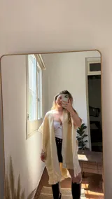 Ruana color crema de lana merino confeccionada artesanalmente con flecos en el borde inferior.