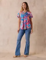 Blusa estampada con motivos florales en tonos rosa, azul y naranja. Tiene cuello en V y mangas cortas con volados.