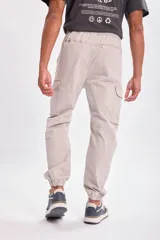 Pantalón cargo jogger gris claro con bolsillos laterales y tobillos ajustados.