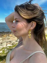 Aros colgantes dorados con diseño irregular en forma de cascada.
