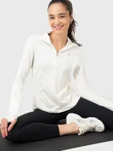 Buzo deportivo blanco de tela suave y delgada con medio cierre frontal, mangas largas con orificios para los pulgares y logo en el pecho.