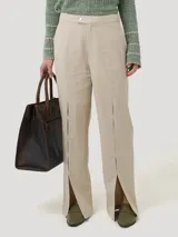 Pantalón de lino orgánico y viscosa color beige, de tiro alto, corte clásico y aberturas en el ruedo.