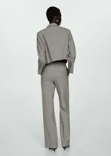 Pantalón de vestir gris con corte acampanado, tiro alto, bolsillos laterales y cierre oculto con botón, gancho y cremallera.