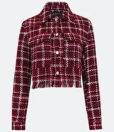 Campera corta de tweed a cuadros en tonos rojo, blanco y negro. Tiene cuello clásico, cierre frontal con botones, dos bolsillos en el pecho y flecos en el dobladillo.
