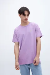 Remera lila con estampa en el pecho y diseño fotográfico de un atardecer en la espalda.