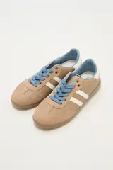 Zapatillas urbanas color beige con detalles en blanco y cordones celestes.