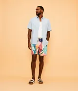 Camisa de hombre de lino color celeste, de manga corta, con cuello camisero, botonadura frontal y un bolsillo en el pecho.