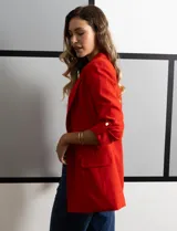 Blazer rojo de crepe marca Tahari, con cuello con solapa y abertura central. Tiene mangas 3/4 regulables con presilla y botón, bolsillos delanteros y forro interno.