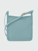 Bandolera Longchamp modelo Le Foulonné, color crudo, con correa fina regulable, cierre superior y logo grabado en el frente.