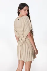Vestido corto color beige de tejido de punto con rayas verticales en relieve. Tiene cuello redondo, mangas cortas tipo kimono y lazo en la cintura.