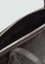Bolso tipo bowling color negro con textura tipo piel de cocodrilo, doble asa larga y cierre de cremallera doble.