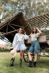 Blusa corta de crochet color blanco con diseño floral en azul y mangas cortas con borde calado.