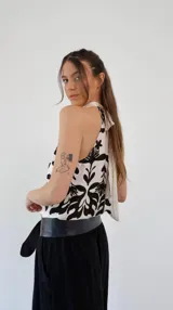 Top de seda estampado en blanco y rojo, con cuello halter y lazo en la espalda.