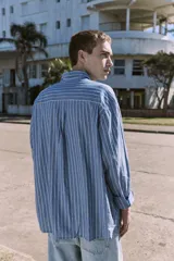 Camisa celeste a rayas verticales blancas, de manga larga, con cuello clásico y corte comfort.