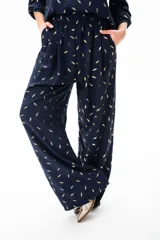 Mono azul con estampado de hojas doradas, mangas 3/4 y pantalón palazzo.