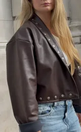 Campera marrón de ecocuero con cuello clásico, corte holgado y cierre frontal con botones a presión.