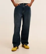 Pantalón de jean azul oscuro, corte balloon, con cintura con trabillas, cierre tradicional y bolsillos.
