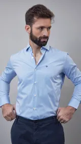 Camisa celeste claro de manga larga con cuello clásico y cierre frontal con botones.
