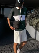 Bandolera negra con correa ajustable y cinco bolsillos.