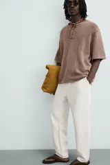Pantalón color arena de corte recto, confeccionado en tejido de algodón y lino. Cuenta con cintura elástica ajustable con cordón, bolsillos delanteros y traseros de parche.