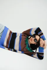 Sweater tejido a rayas horizontales en tonos marrón, beige, azul y negro, con bordados de flores en el frente.