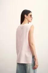 Blusa color crema sin mangas, de lino, con cuello redondo y corte recto.