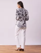 Blusa de gasa estampada con cuello a la base, escote en V y botones. Delantera con detalle plisado y largo de manga regulable con presilla y botón.