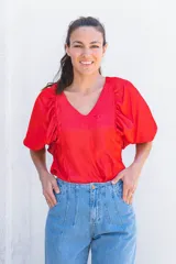 Blusa azul de escote pico y manga corta con volados en la parte delantera.