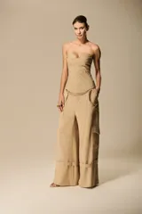 Pantalón cargo de corte amplio color beige, con bolsillos laterales y tiras ajustables en el ruedo.