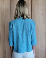 Camisa color beige claro con cuello con volados y mangas 3/4 abullonadas.