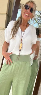 Colgante largo con cordón de cuero marrón y cuentas de madera y resina color crema.