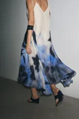 Vestido midi de tirantes finos ajustables, confeccionado en ramio color blanco con estampado abstracto en tonos azules.