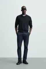 Pantalón chino color beige, corte skinny fit, confeccionado en tejido con mezcla de algodón y elasticidad. Cuenta con bolsillos frontales y traseros. Cierre frontal con cremallera y botón.