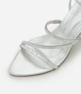 Sandalias plateadas de tacón fino, con punta cuadrada y tiras finas con apliques brillantes. Incluye tira con hebilla alrededor del tobillo.