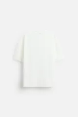 Camiseta negra de corte holgado, con cuello redondo y mangas cortas.