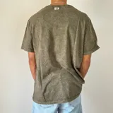 Remera gris con efecto gastado y cuello redondo.