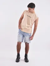 Musculosa color beige con estampado de calavera, rayos y la frase "No Defeat". Corte oversize.