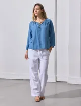 Blusa celeste de lyocell con cuello a la base y escote en V con lazo de ajuste. Manga larga amplia.
