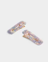 Set de dos hebillas rectangulares para el pelo con diseño abstracto en tonos lila, beige y azul.