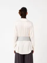 Camisa básica de corte amplio, confeccionada en tejido especial con textura arrugada, que aporta un aire elegante y sofisticado.