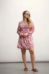 Vestido corto con estampado abstracto en tonos rosa y beige, escote en V, mangas largas abullonadas con puños elásticos y corte evasé.