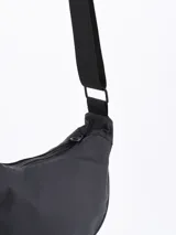 Bandolera negra de tela impermeable con correa ancha regulable.